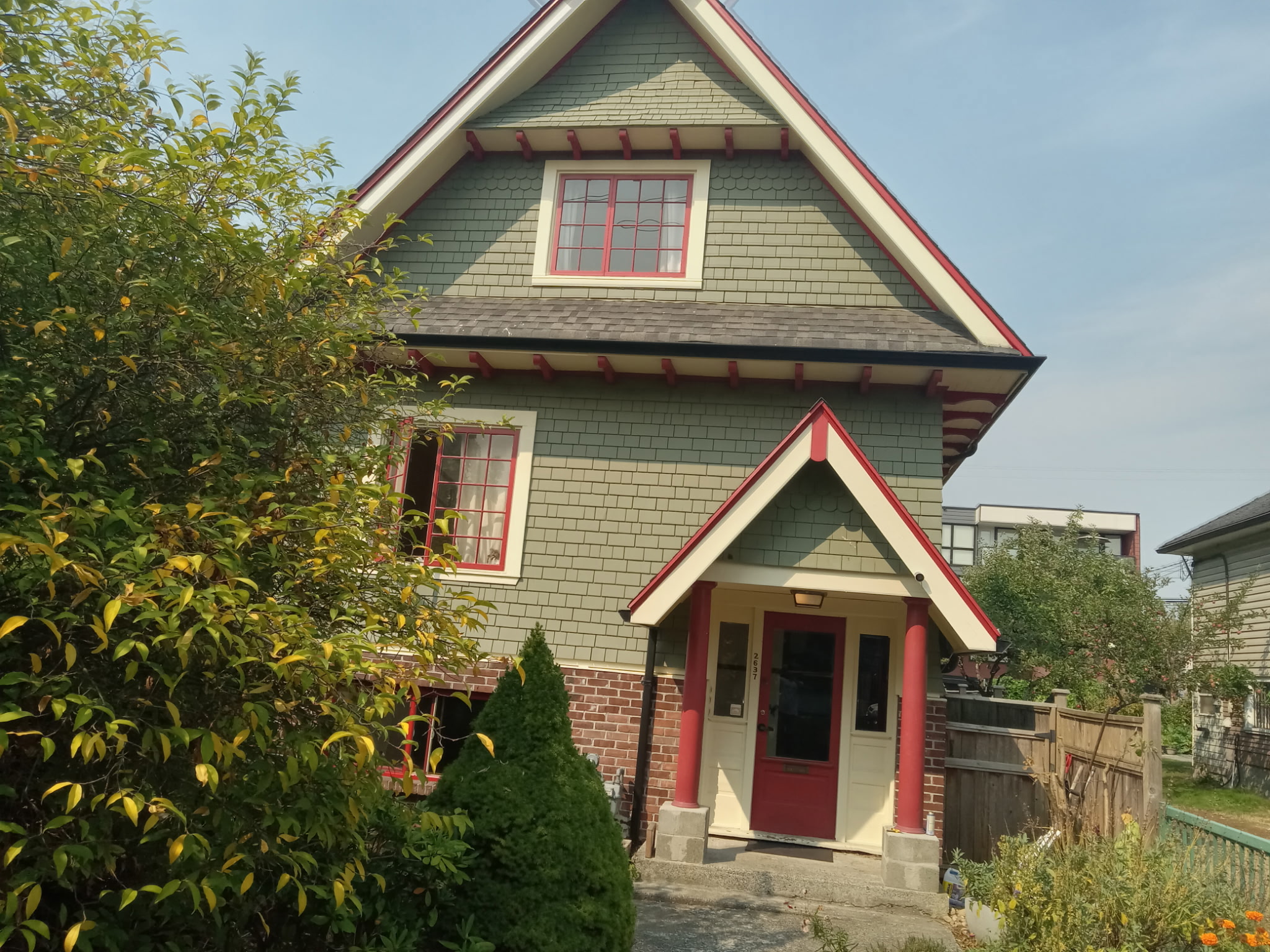 Finished front entrance with red door, trim, and porch details